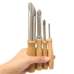 Close-up detail view of four different sizes clay hole punch tools with wooden handles.