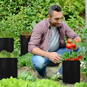 Zwarte stoffen plantenzakken voor aardappelen en groenten in de tuin, gedetailleerd.