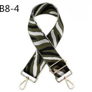 Detail view of green zebra print bag strap with durable gold hardware and adjustable buckle.