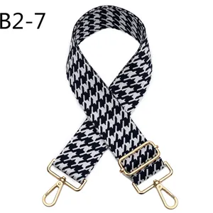 Black and white houndstooth replacement bag strap with golden hardware, adjustable cross-body.