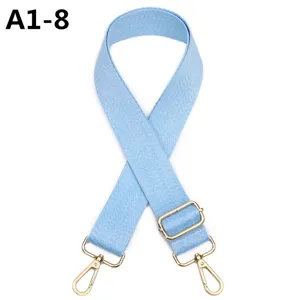 Primer plano de correa de bolso azul claro con herrajes dorados ajustables y ganchos.