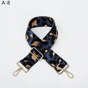 Primer plano detallado de la correa de bolso de leopardo azul con hebillas de metal dorado.