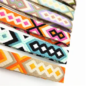 Primer plano de correa de bolso étnica bordada colorida con patrones de diamantes geométricos.