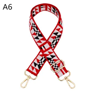 Detailed view of a colorful ethnic style bag strap with adjustable gold metal hardware.