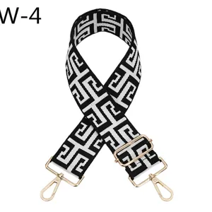Replacement black white geometric jacquard bag strap with adjustable gold metal hardware.