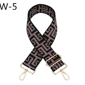 Adjustable wide jacquard handbag strap with gold tone hardware and geometric pattern.