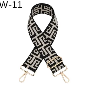 Adjustable replacement bag strap with black and white ethnic jacquard pattern and gold hardware.