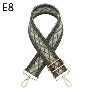 Close-up of ethnic woven bag strap with geometric diamond pattern and gold metal hardware.