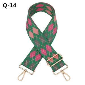 Vue détaillée de la bandoulière de sac réglable avec un motif à losanges vert et rose classique.