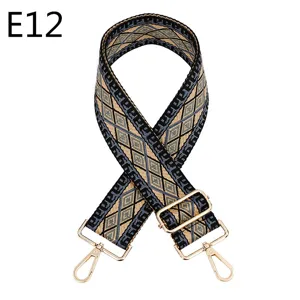 Close up of ethnic geometric woven bag strap with adjustable gold metal hardware and clasps.