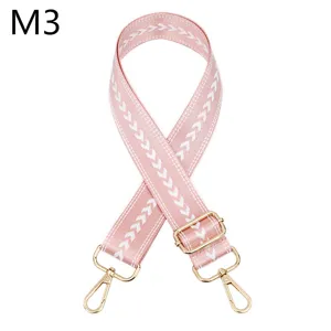 Nahaufnahme des verstellbaren rosa Taschengurt mit Zickzack-Muster und goldener Hardware.