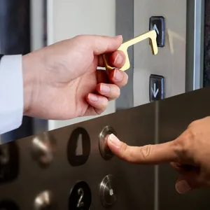 Brass EDC contactless door opener tool for safe elevator button pressing and hygiene protection.