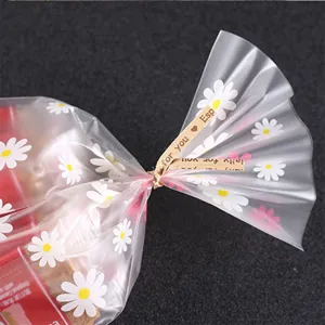 Detailed shot of clear bakery packaging bags with daisy print and kraft paper twist ties.