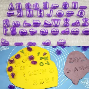 Close-up detail of plastic letter and number cookie molds stamping dough for baking decoration.