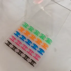 Vista detallada de bobinas de máquina de coser de colores en una caja organizadora.