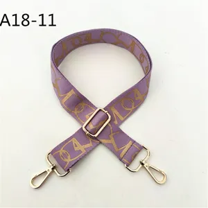 Correa de bolso tejida morada ajustable con patrón de monograma de lujo y herrajes dorados.