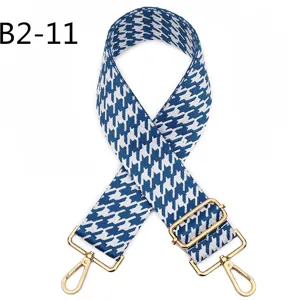 Blue and white houndstooth jacquard bag strap detail with adjustable gold metal hardware.