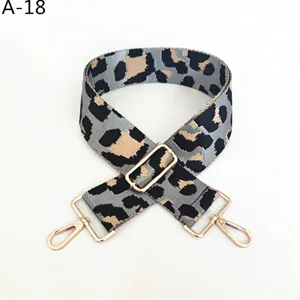 Detalle de correa de bolso de repuesto con estampado de leopardo gris y herrajes dorados ajustables.