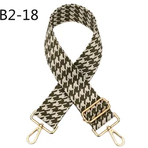 Detail view of adjustable houndstooth replacement shoulder strap with gold hardware hooks.