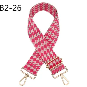 Detailed closeup of the pink houndstooth jacquard replacement bag strap with gold metal hardware.
