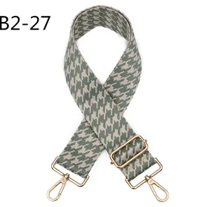 Houndstooth bag strap detail, adjustable green replacement strap with gold hardware close-up.