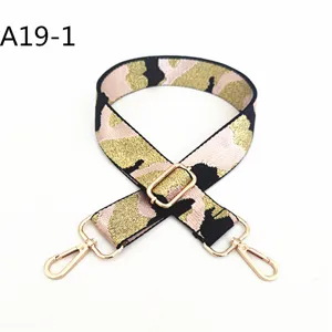Detailed view of the pink and black camo handbag strap with shiny gold swivel hooks and buckle.