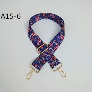 Détail de la bandoulière large avec motif cache-mire ethnique et crochets métalliques.