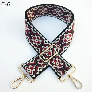 Detailed view of the ethnic style jacquard bag strap with adjustable metal hardware.