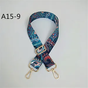 Gros plan sur la large sangle de sac ethnique et réglable avec de belles boucles dorées.