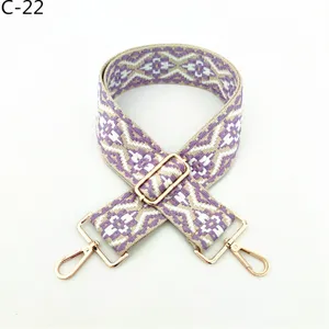 Close-up of ethnic jacquard bag strap with adjustable gold metal hardware and durable clasps.