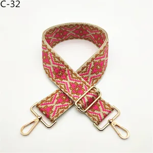 Detailed view of ethnic jacquard bag strap with geometric pattern and gold hardware.