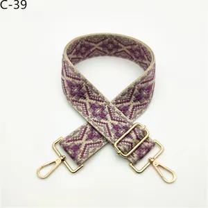 Detailed view of ethnic jacquard bag strap with gold hardware and adjustable length.