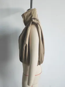 Vista dettagliata laterale di un gilet smanicato plissettato beige con collo alto chic.