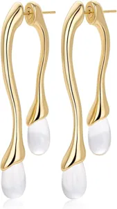 Gros plan détaillé des boucles d'oreilles pendantes dorées avec cristaux transparents.