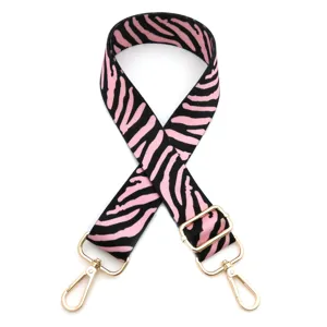 Close-up detail of the pink and black zebra print bag strap with durable gold metal buckles.