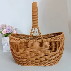 Brown woven picnic basket detail view, portable storage basket with handle and heart design.