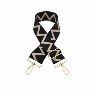 Courroie de sac de rechange réglable à motif chevron noir et beige avec boucles dorées.