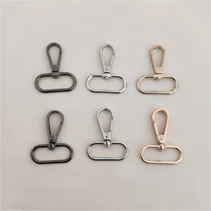 Primer plano de mosquetones giratorios de metal y anillas para bolsos en varios colores.