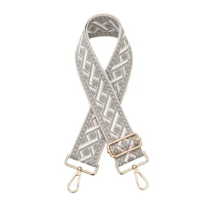 Vue détaillée d'une lanière de sac de rechange en jacquard tissé gris et blanc, quincaillerie dorée.