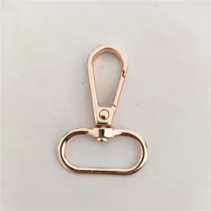 Detalle de primer plano de un mosquetón giratorio de metal en oro rosa para bolsos y manualidades.