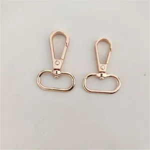 Detalles en primer plano de mosquetones giratorios de metal oro rosa para bolsos, aleación.