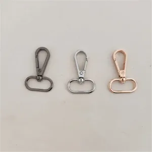 Primer plano de mosquetones metálicos con acabados en color plomo, plata y oro rosa.