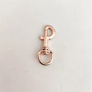 Close-up detail of a rose gold metal lobster clasp, swivel snap hook for DIY bags and keychains.