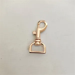 Rose gold metal lobster clasp detail, swivel snap hook hardware for bags and keychains.