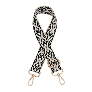 Detailed view of the ethnic black white geometric bag strap with gold adjustable metal buckles.