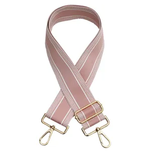 Ancha correa de repuesto para bolso en tela rosa con hebillas metálicas doradas.