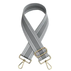 Ancha correa de bolso gris a rayas con herrajes de metal dorado para bolsos cruzados.