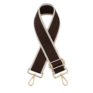 Vue détaillée d'une bandoulière de sac géométrique marron et beige avec des accessoires dorés.