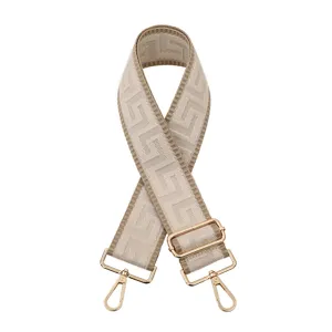 Vue détaillée de la sangle de sac géométrique beige avec quincaillerie dorée réglable.