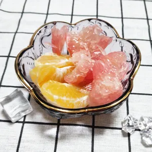 Detailansicht einer kreativen japanischen Glas-Blumenschale mit Goldrand und frischen Fruchtstücken.
